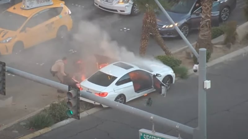 A dramatic video shows an officer pulling a driver out of a burning car.